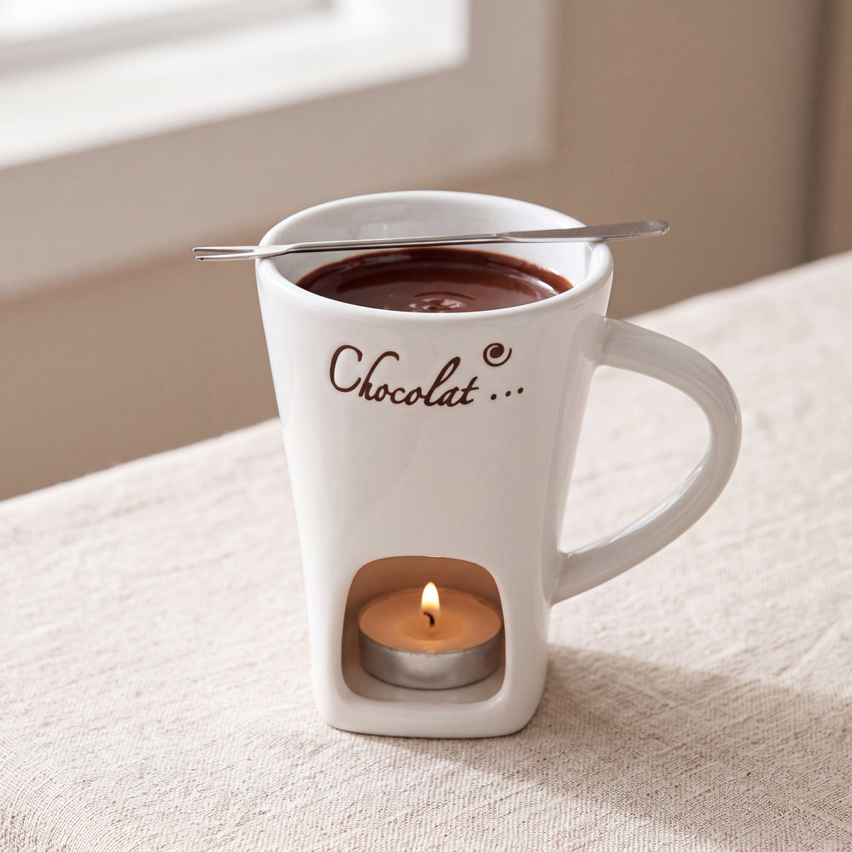 Taza fondue de chocolate blanca con vela encendida en la base